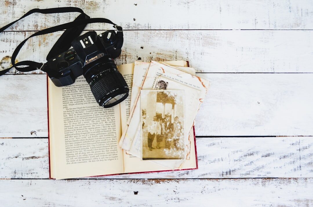Camera equipment and printed photographs laid out on a wooden table
