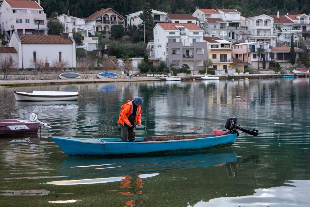 Documentary photographer photographing an elderly Croatian fisherman on a wooden boat